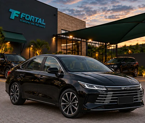 BYD King preto estacionado diante de uma fachada com o logo Fortal, ao entardecer